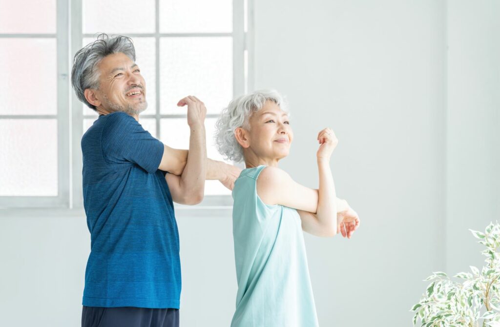 a senior couple exercise together at home.
