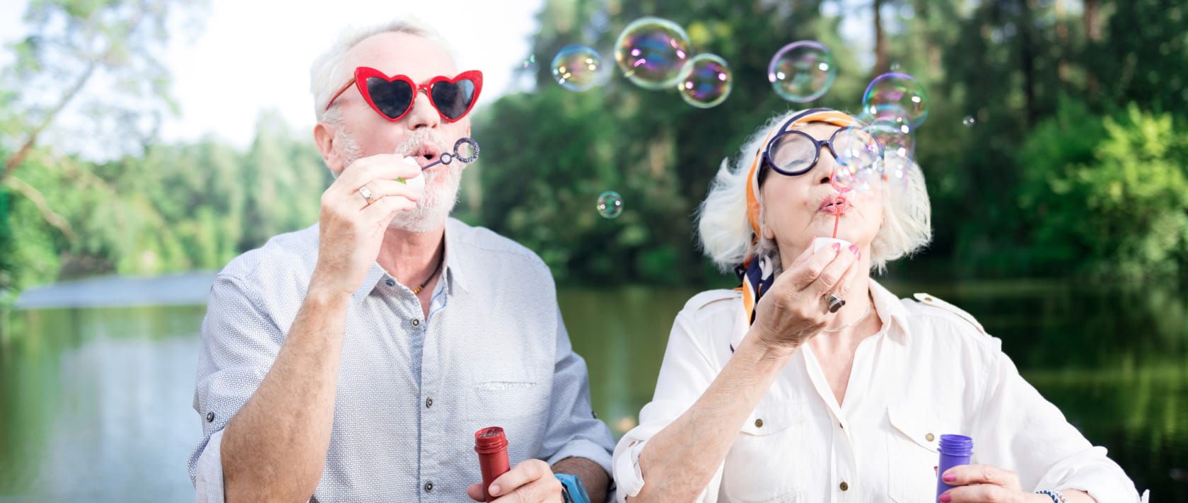 elderly couple wearing glasses and blowing bubbles - different aspect ratio