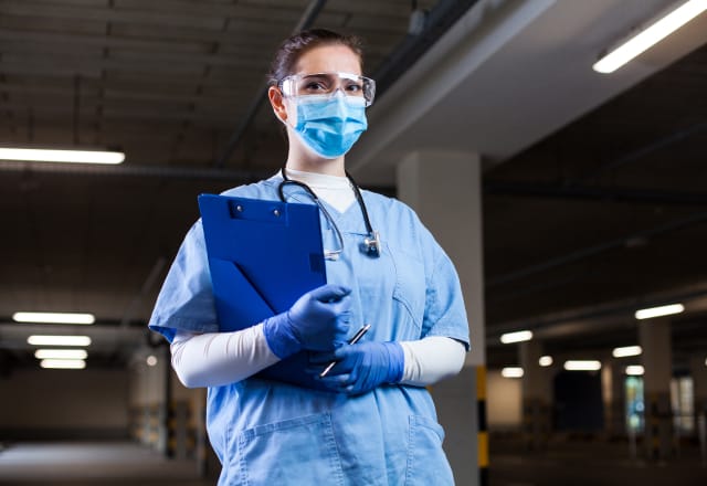 masked medical technician with clipboard