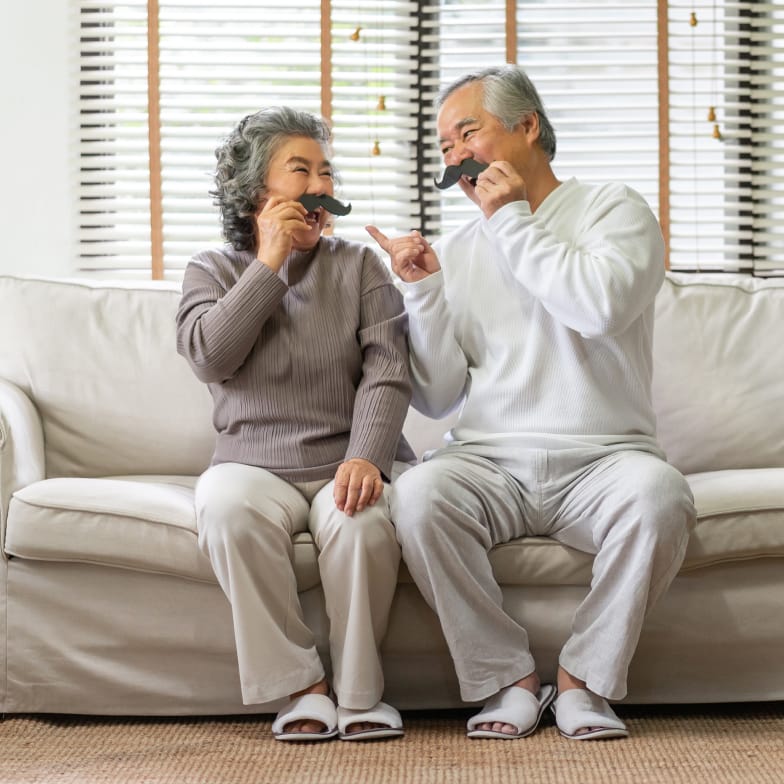 senior couple playing with mustaches - square