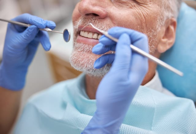 smiling male patient having his teeth cleaned